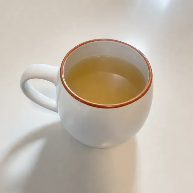 Caneca branca com caldo de ossos Caldo Santo quente.